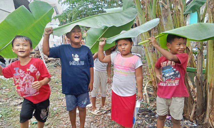 Anak -anak di Pemalang Manfaatkan Daun Pisang Untuk Payung Saat Hujan Tiba 